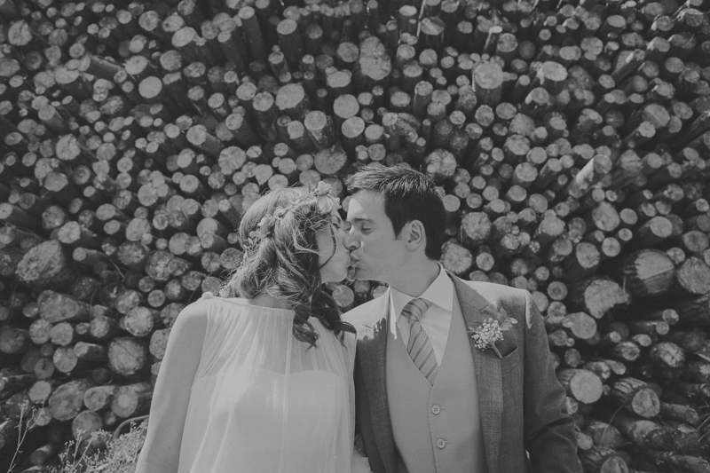 Foto de boda de pareja dándose un beso, estilo boho.